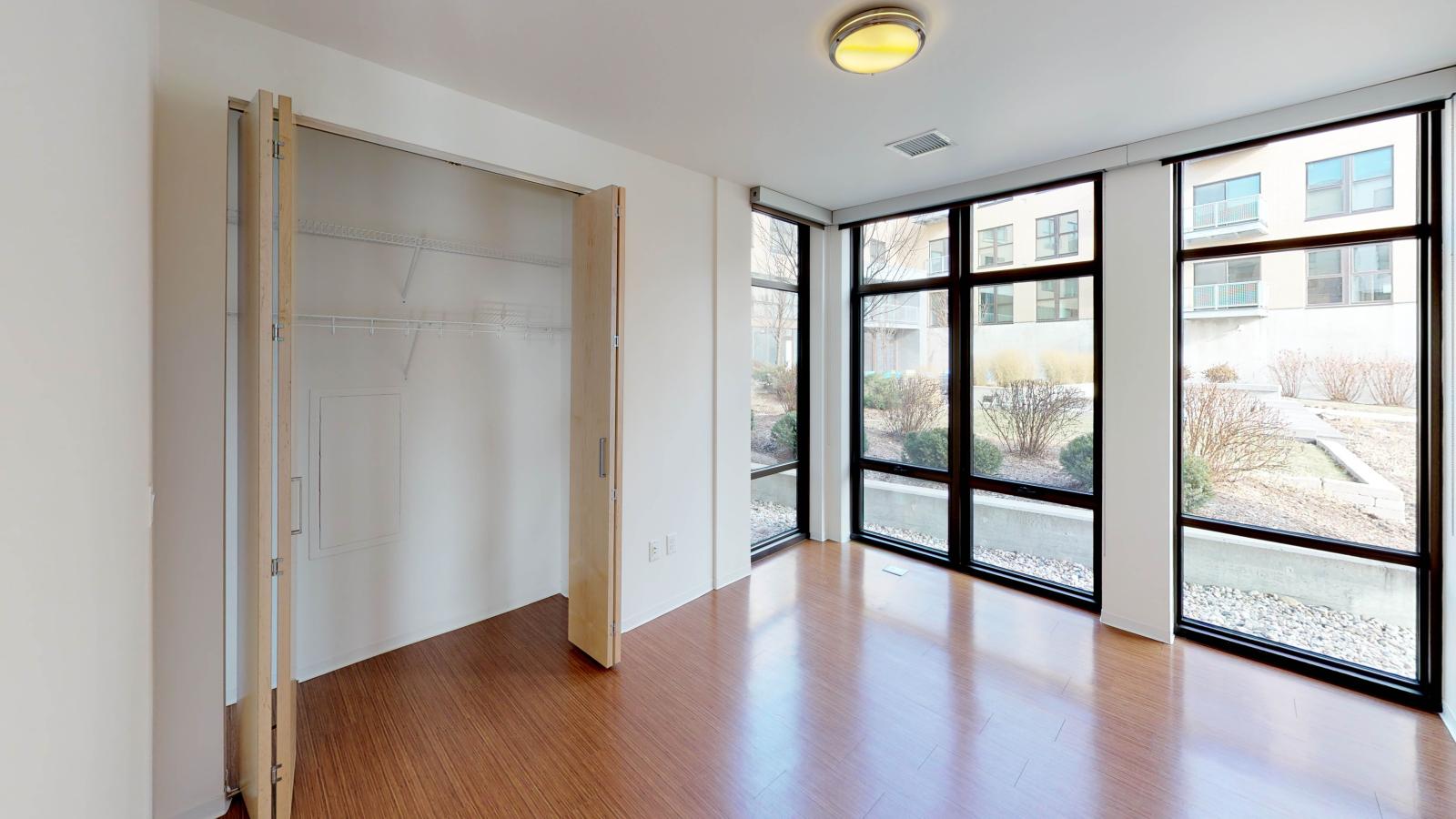 Guest bedroom in a two bedroom apartment with standard closet and soft neutral tones at SEVEN27