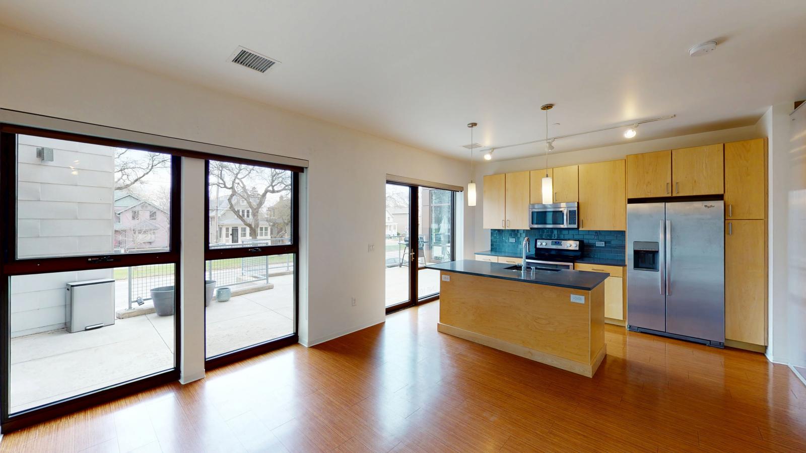 One bedroom with patio, natural light and Luxury kitchen with high end finishes and quartz countertops at SEVEN27 in downtown Madison