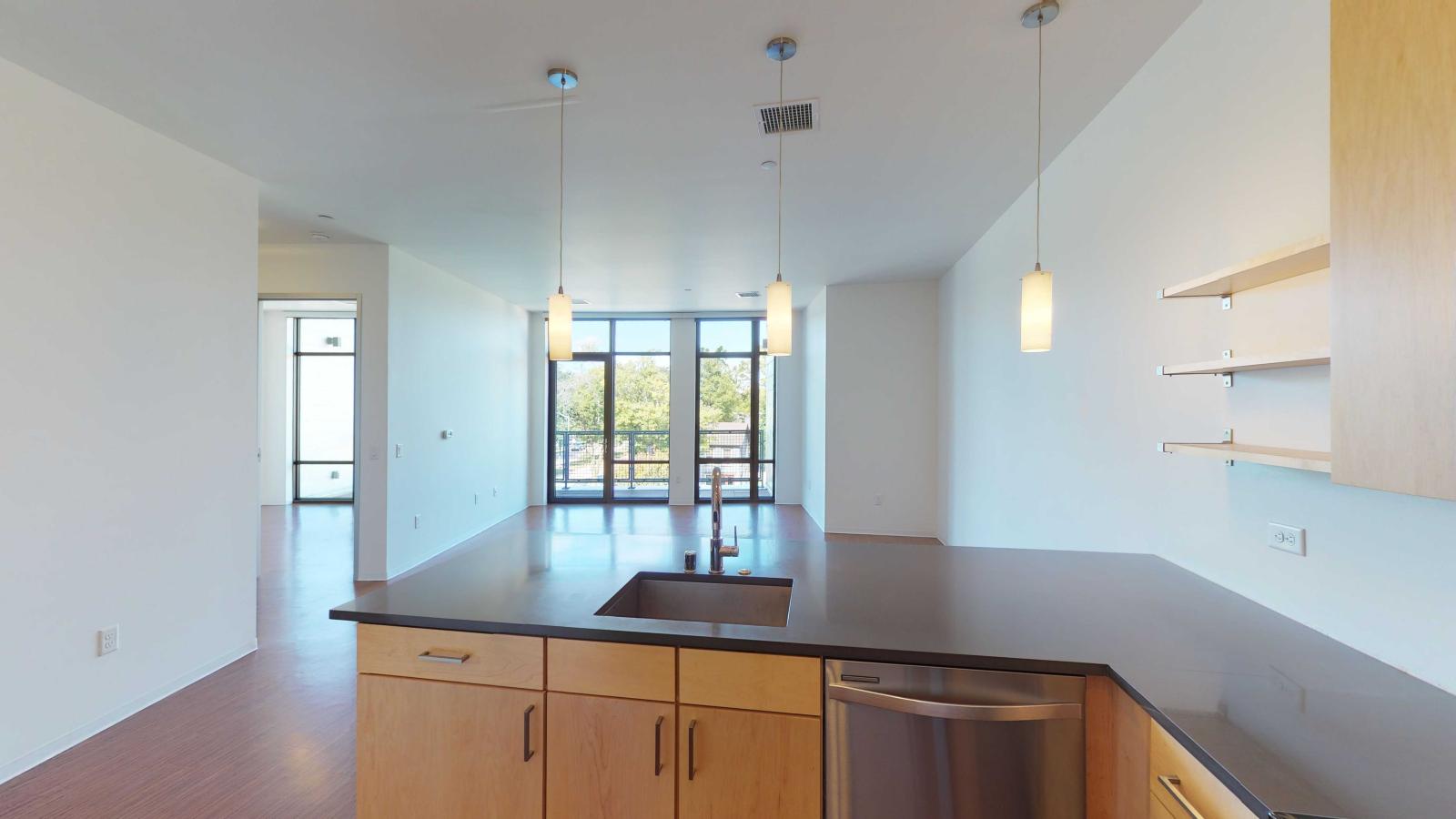 One bedroom apartment kitchen with open shelving and stainless steel appliances at SEVEN27
