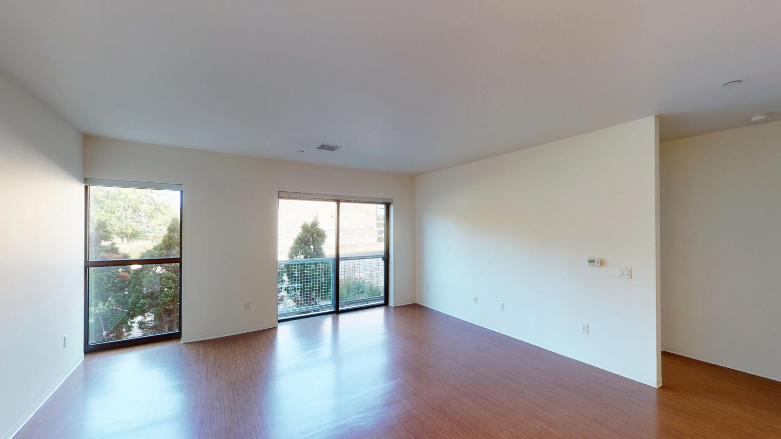 Spacious living room with Juliette balcony doors and natural light in a one bedroom apartment at SEVEN27 in downtown Madison