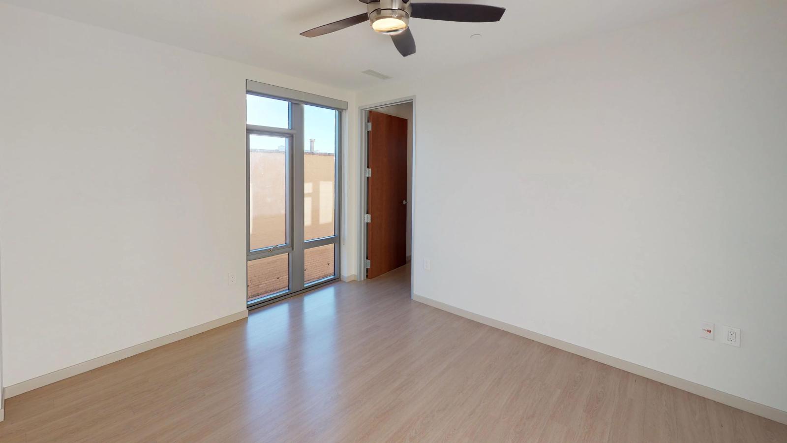 Stylish apartment bedroom at The Pressman in downtown Madison with large windows and ample closet space.