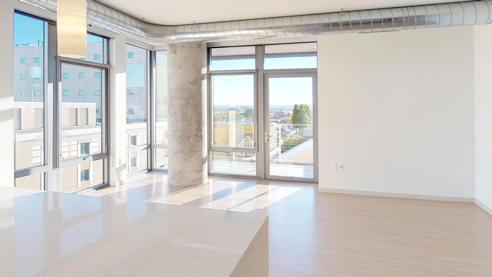 Contemporary one-bedroom apartment at The Pressman in downtown Madison featuring floor-to-ceiling windows and a private balcony.
