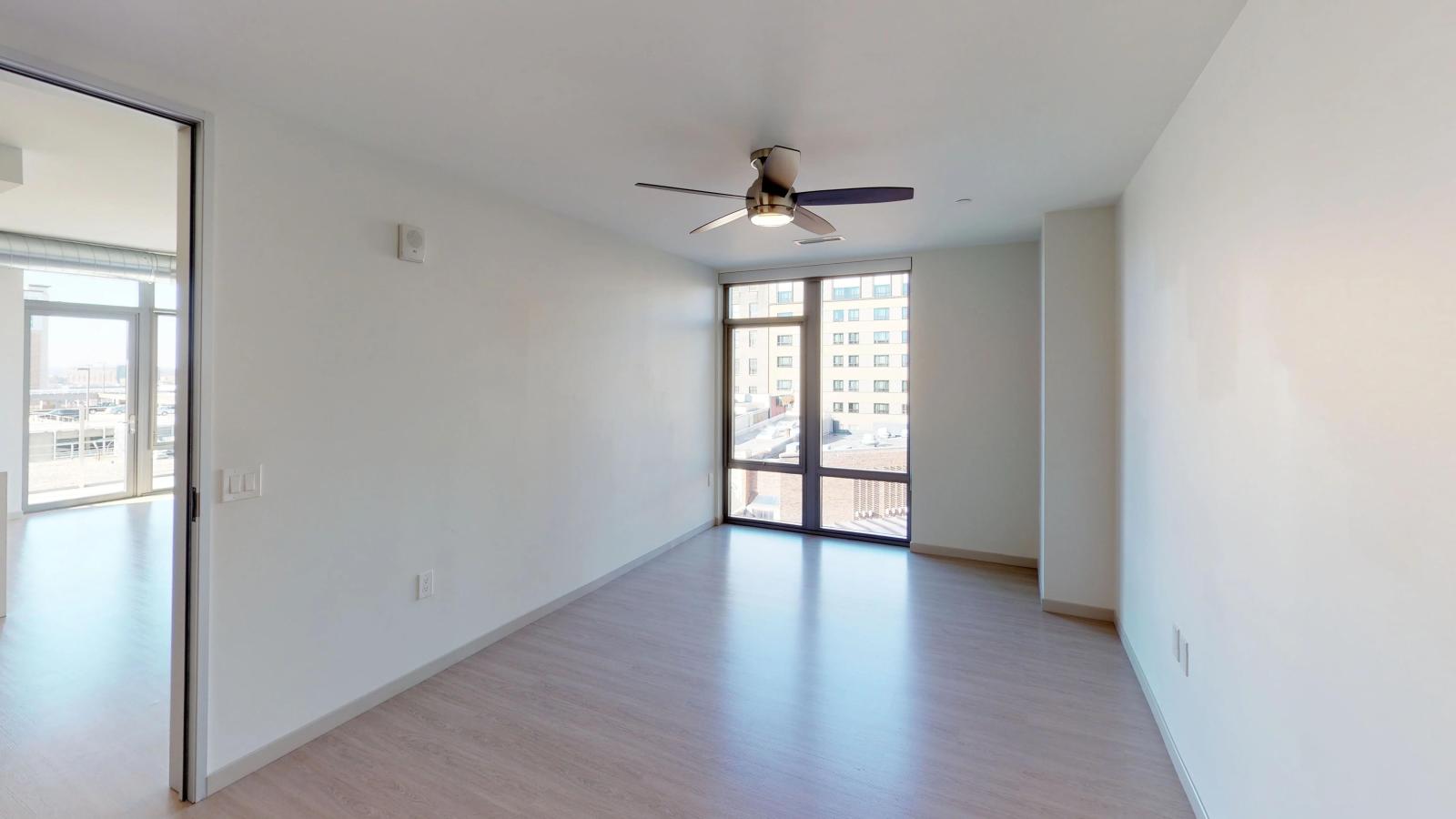 Stylish apartment bedroom at The Pressman in downtown Madison with large windows and ample closet space.