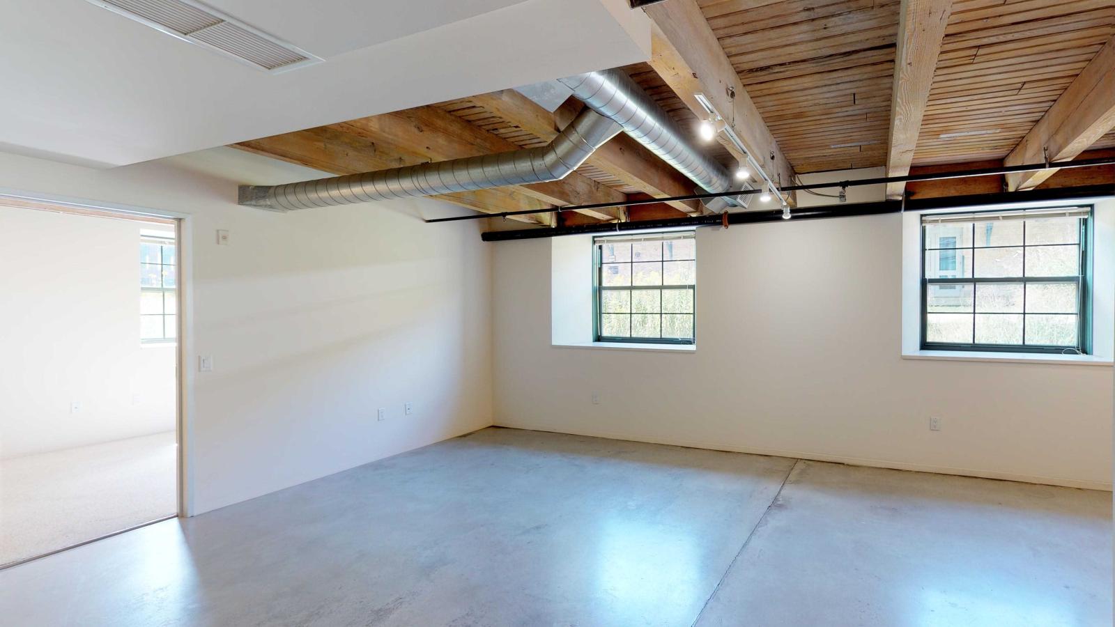 Garden-level one-bedroom apartment with polished concrete floors and industrial-style lighting at Tobacco Lofts