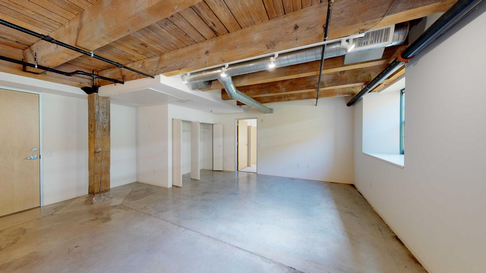 Spacious one-bedroom with open-concept living and historic architectural details at Tobacco Lofts