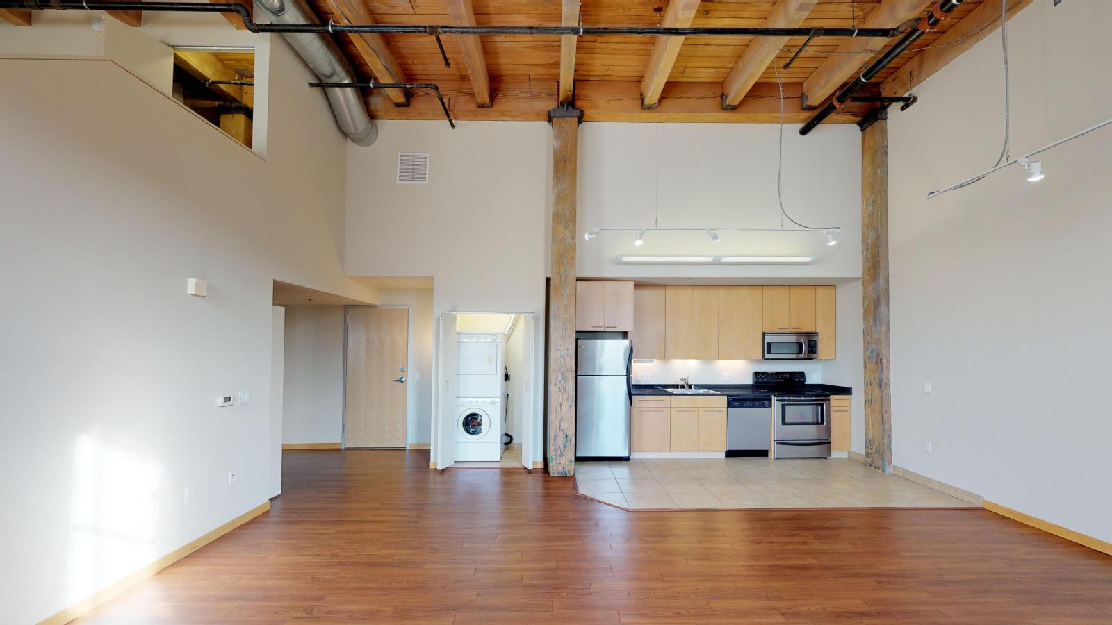 Two bedroom apartment with industrial style kitchen featuring stainless steel appliances at Tobacco Lofts