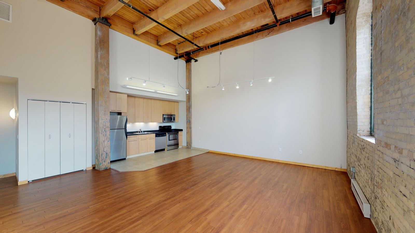 Two bedroom apartment with industrial style kitchen featuring stainless steel appliances at Tobacco Lofts