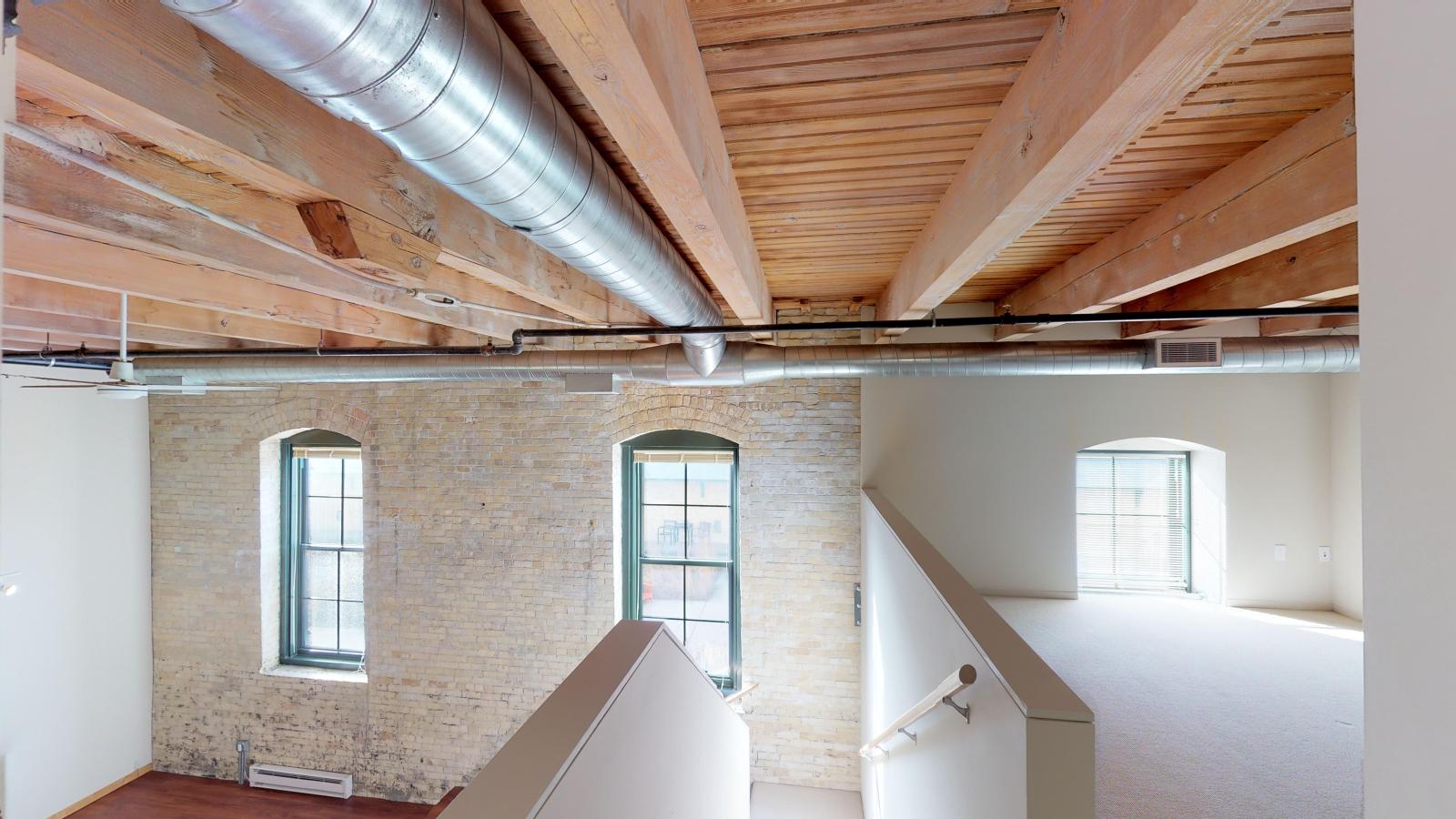 Spacious lofted two bedroom featuring a mezzanine style upstairs primary suite at Tobacco Lofts