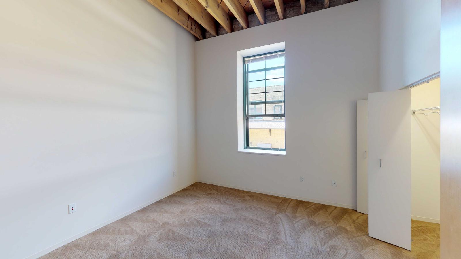 Industrial style one bedroom with expansive windows allowing abundant natural light at Tobacco Lofts