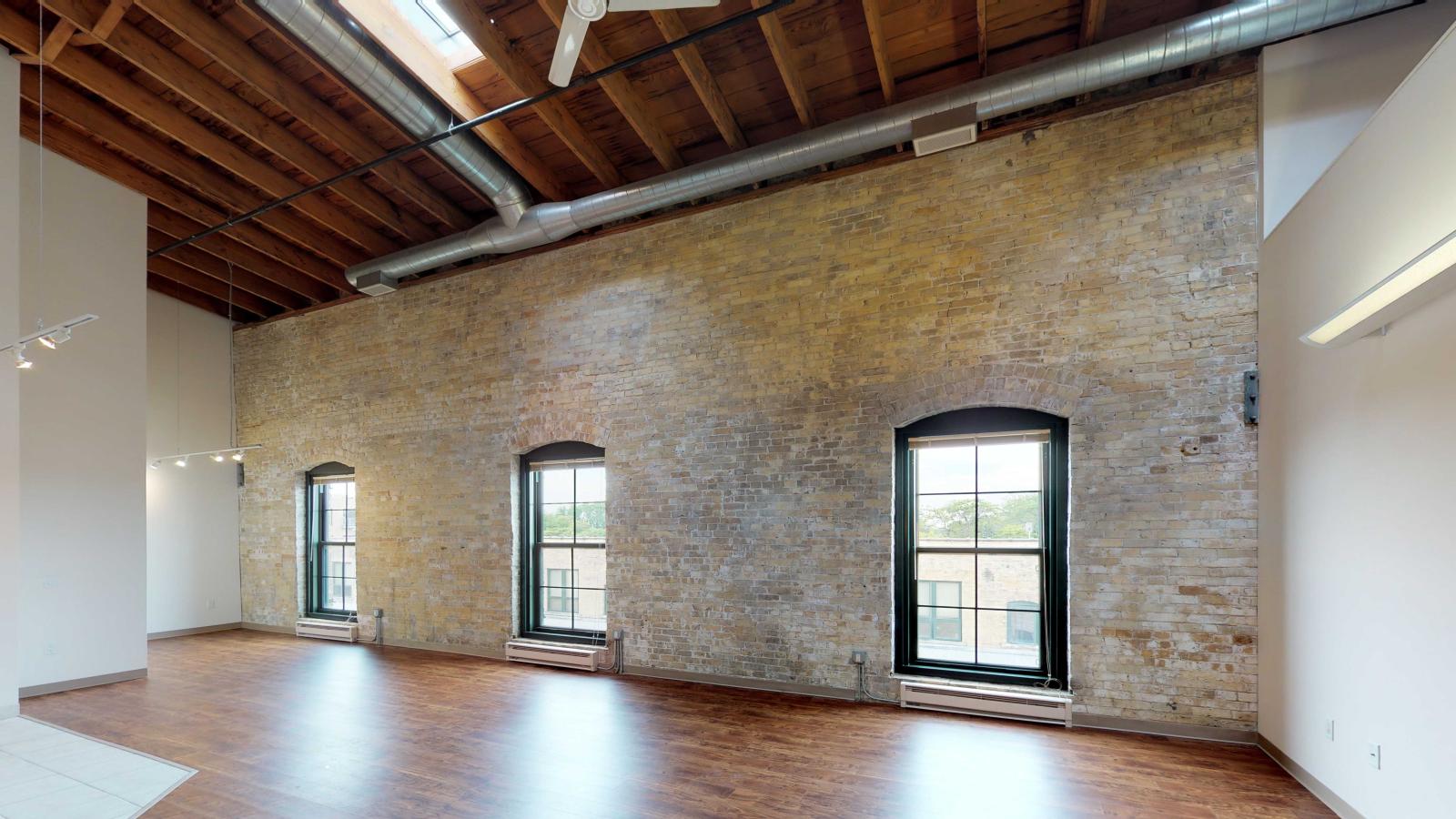 Loft style two bedroom featuring exposed brick walls and restored heavy timber beams at Tobacco Lofts