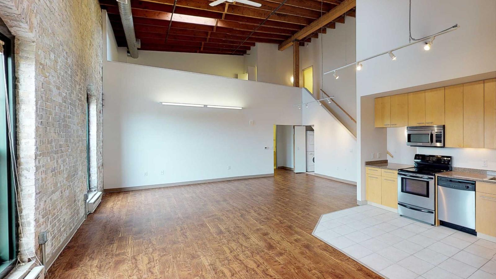 Two bedroom loft with an open staircase leading to the upstairs primary bedroom and ensuite bathroom at Tobacco Lofts