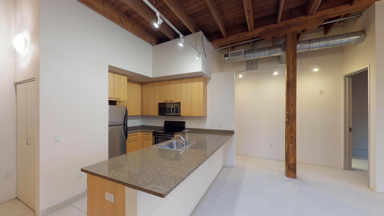 Contemporary kitchen in a one bedroom apartment with ample counter space at Tobacco Lofts