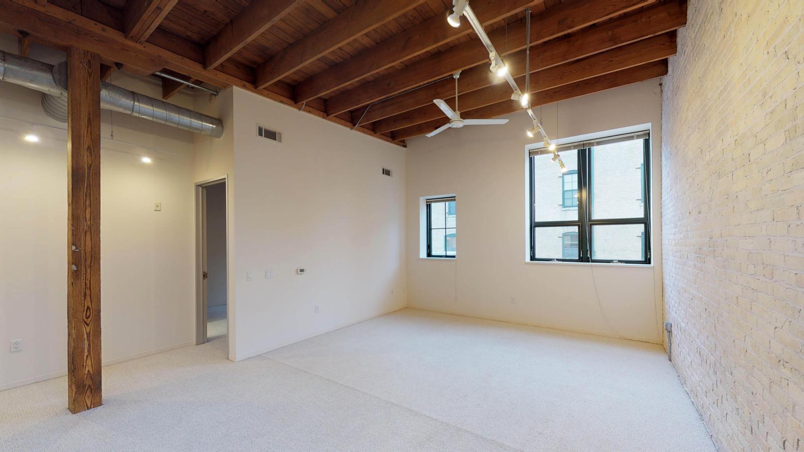 Bright one bedroom apartment with large windows, exposed brick, and high ceilings at Tobacco Lofts