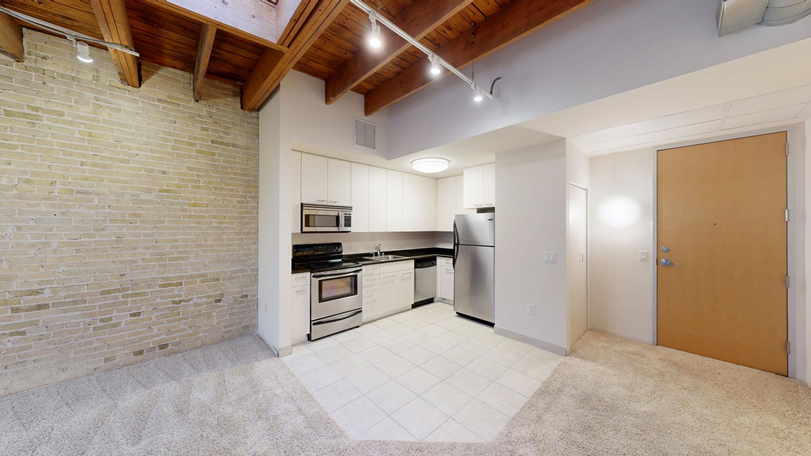 Modern kitchen in a one bedroom apartment with ample counter space and granite countertops at Tobacco Lofts at The Yards in downtown Madison