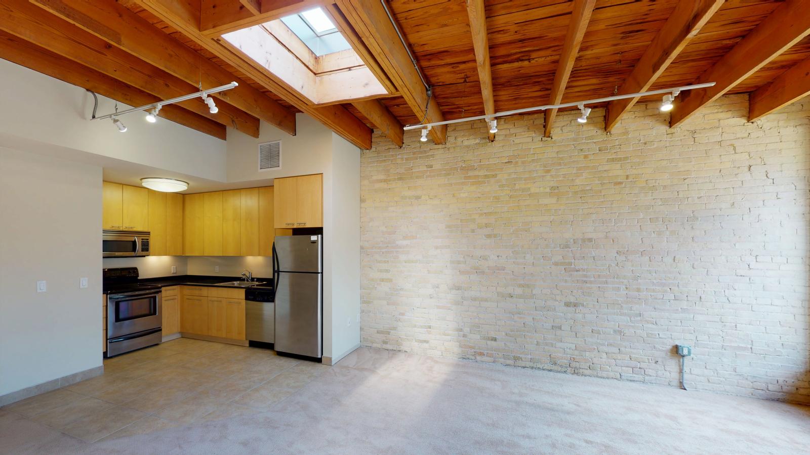 Modern kitchen in a one bedroom apartment with ample counter space and granite countertops at Tobacco Lofts at The Yards in downtown Madison