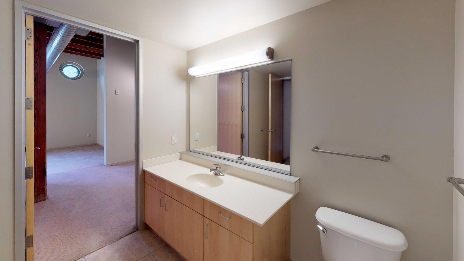 Updated bathroom with minimalist vanity in a studio at Tobacco Lofts