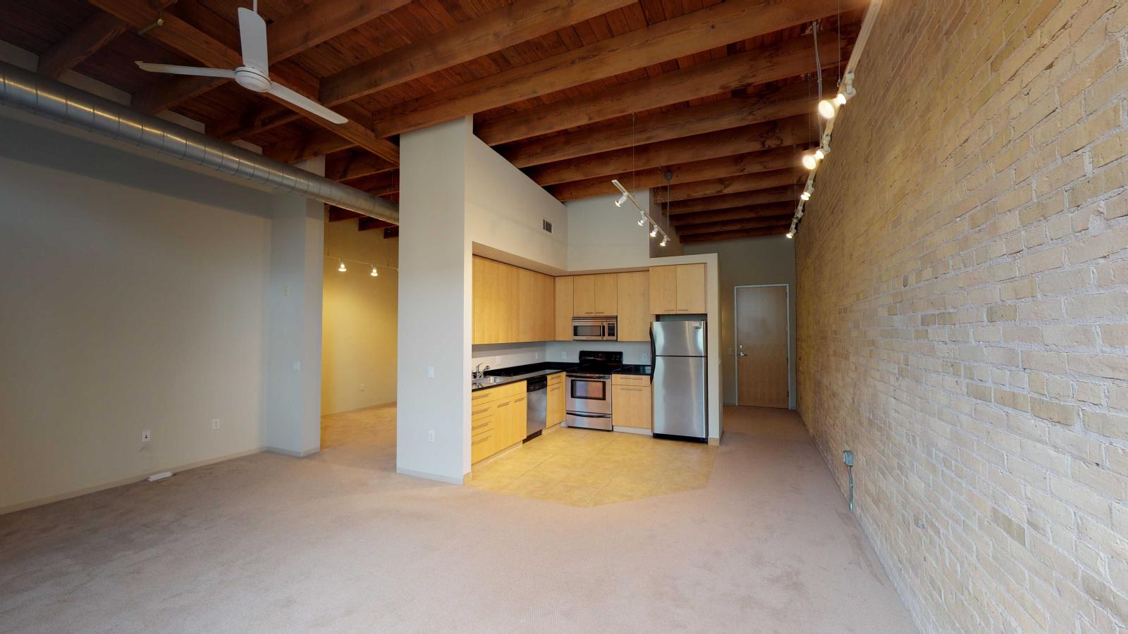 Studio apartment with an open-concept kitchen, modern appliances, and ample storage at Tobacco Lofts