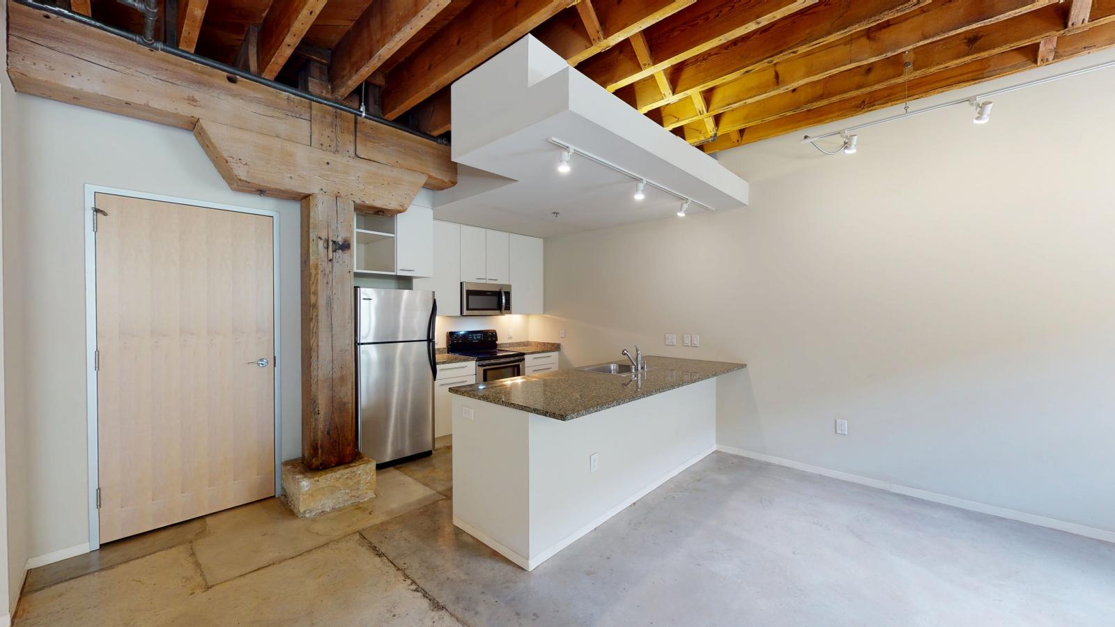 Contemporary kitchen in a one bedroom apartment with ample counter space at Tobacco Lofts Apartment E108