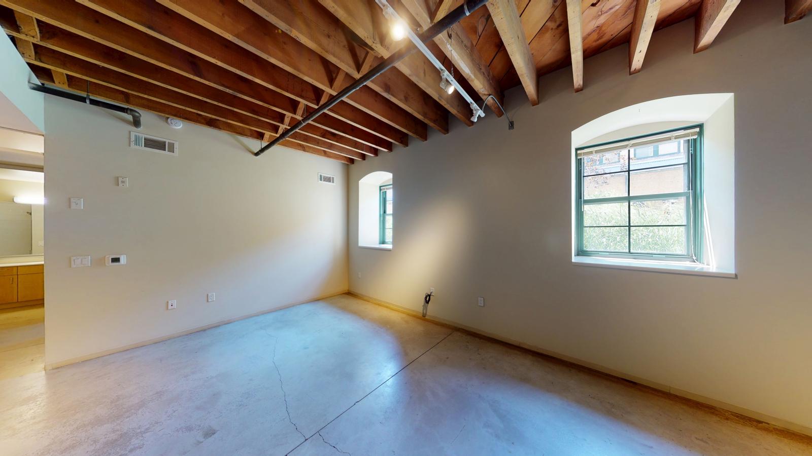 Industrial style one bedroom with polished concrete flooring and open concept design at Tobacco Lofts Apartment E110