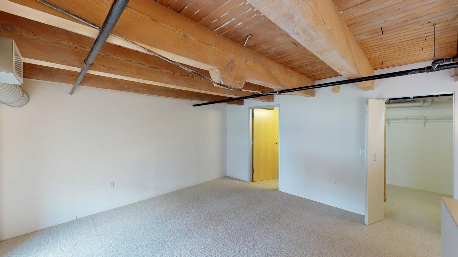 Industrial style two bedroom apartment with the primary bedroom and private bathroom located upstairs at Tobacco Lofts