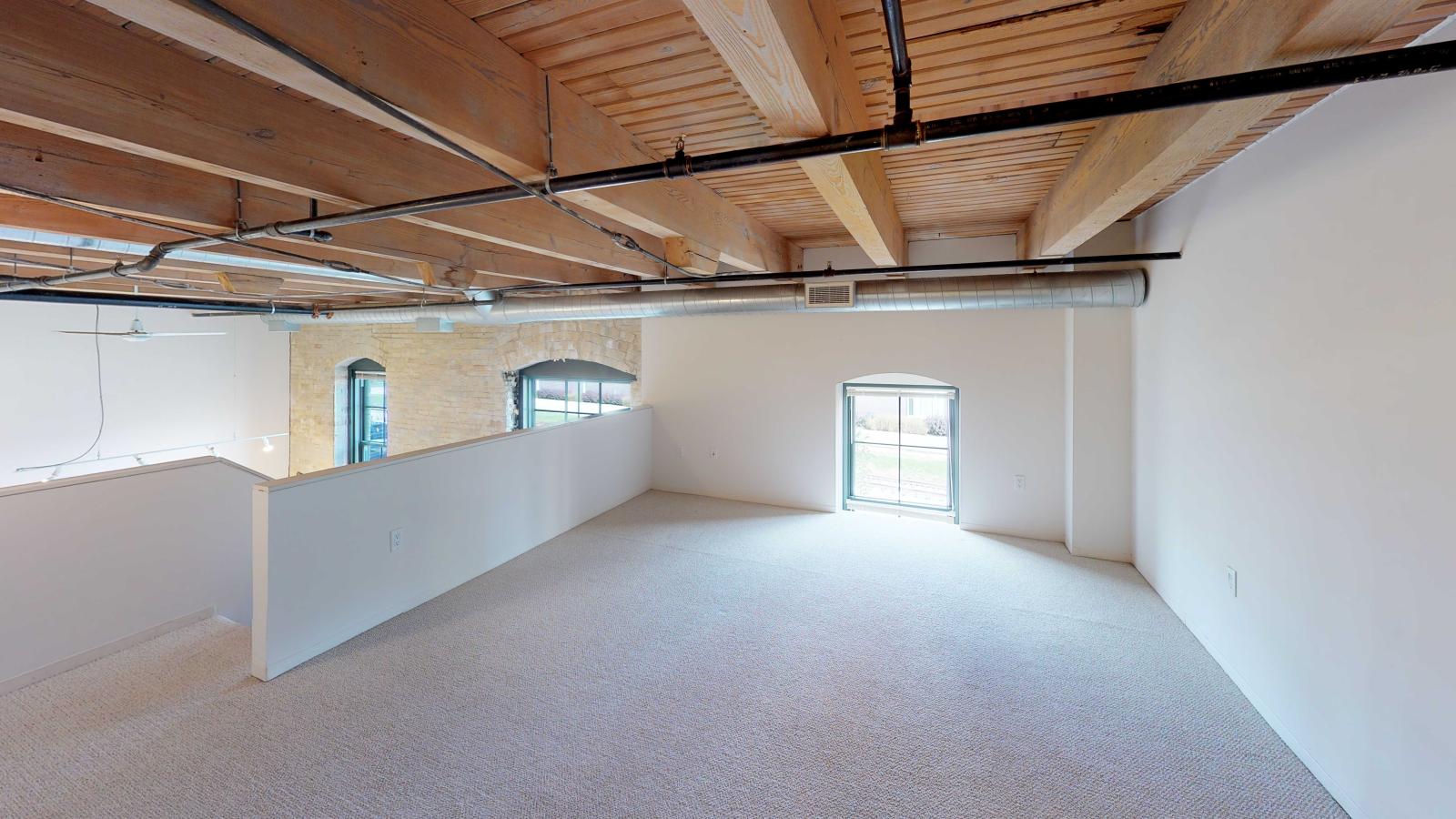 Spacious lofted two bedroom featuring a mezzanine style upstairs primary suite at Tobacco Lofts