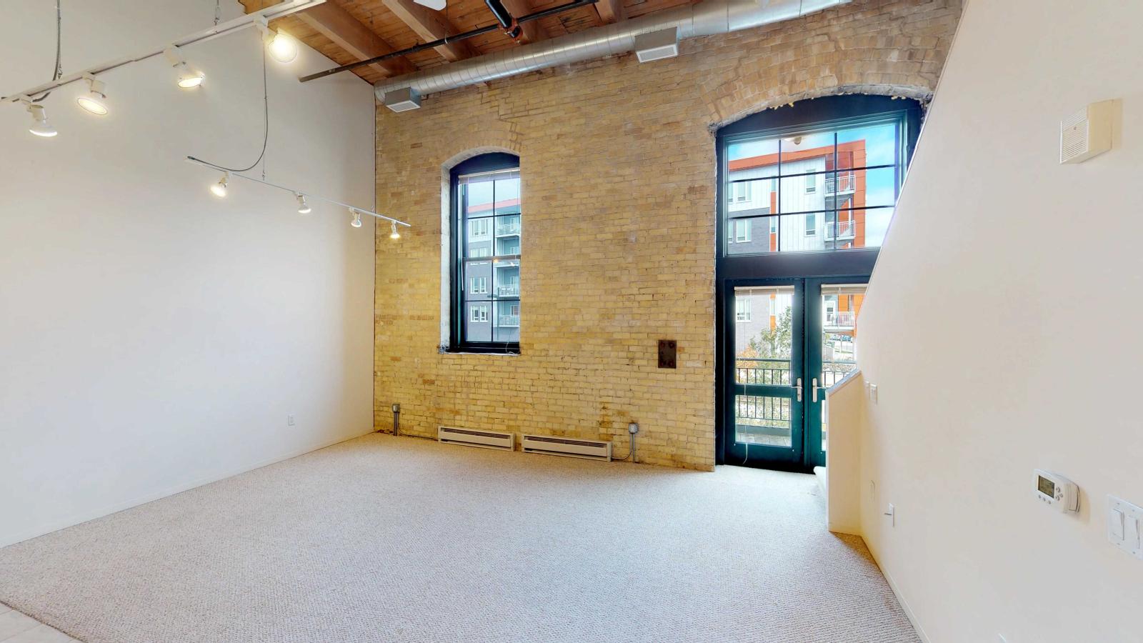 Loft-style two-bedroom apartment with exposed brick, high ceilings, balcony and industrial design at Tobacco Lofts