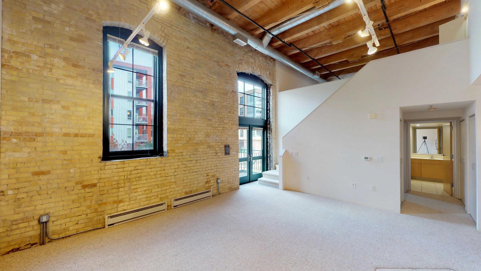 Loft-style two-bedroom apartment with exposed brick, high ceilings, balcony and industrial design at Tobacco Lofts