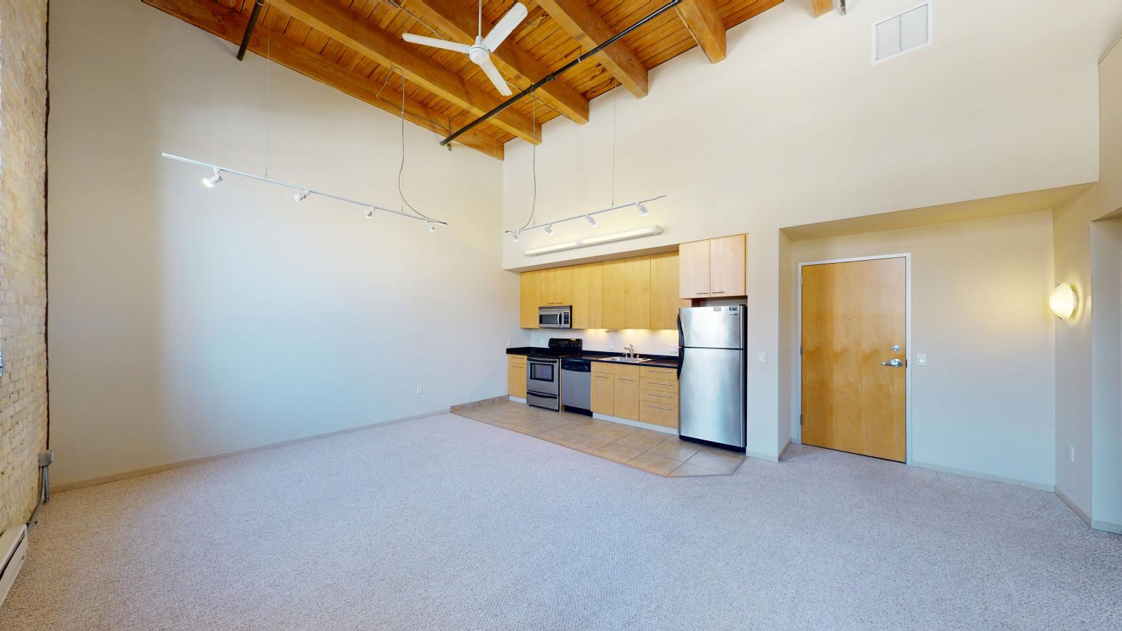 Two bedroom apartment with industrial style kitchen featuring stainless steel appliances at Tobacco Lofts Apartment E205