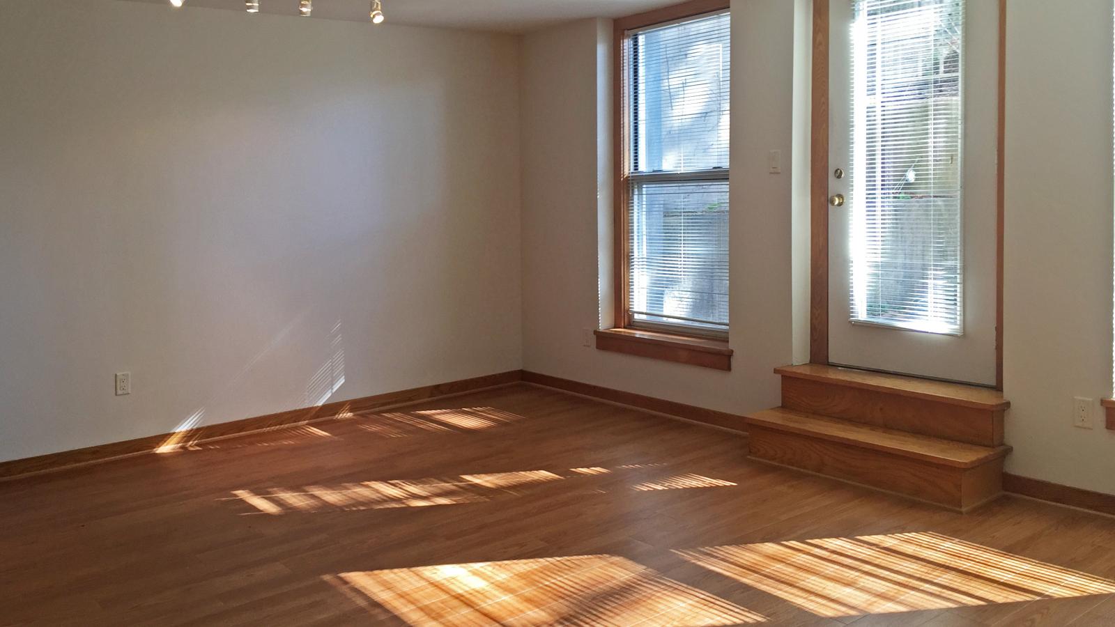 Spacious two-bedroom apartment living room with large windows, private patio and natural light at Lincoln School
