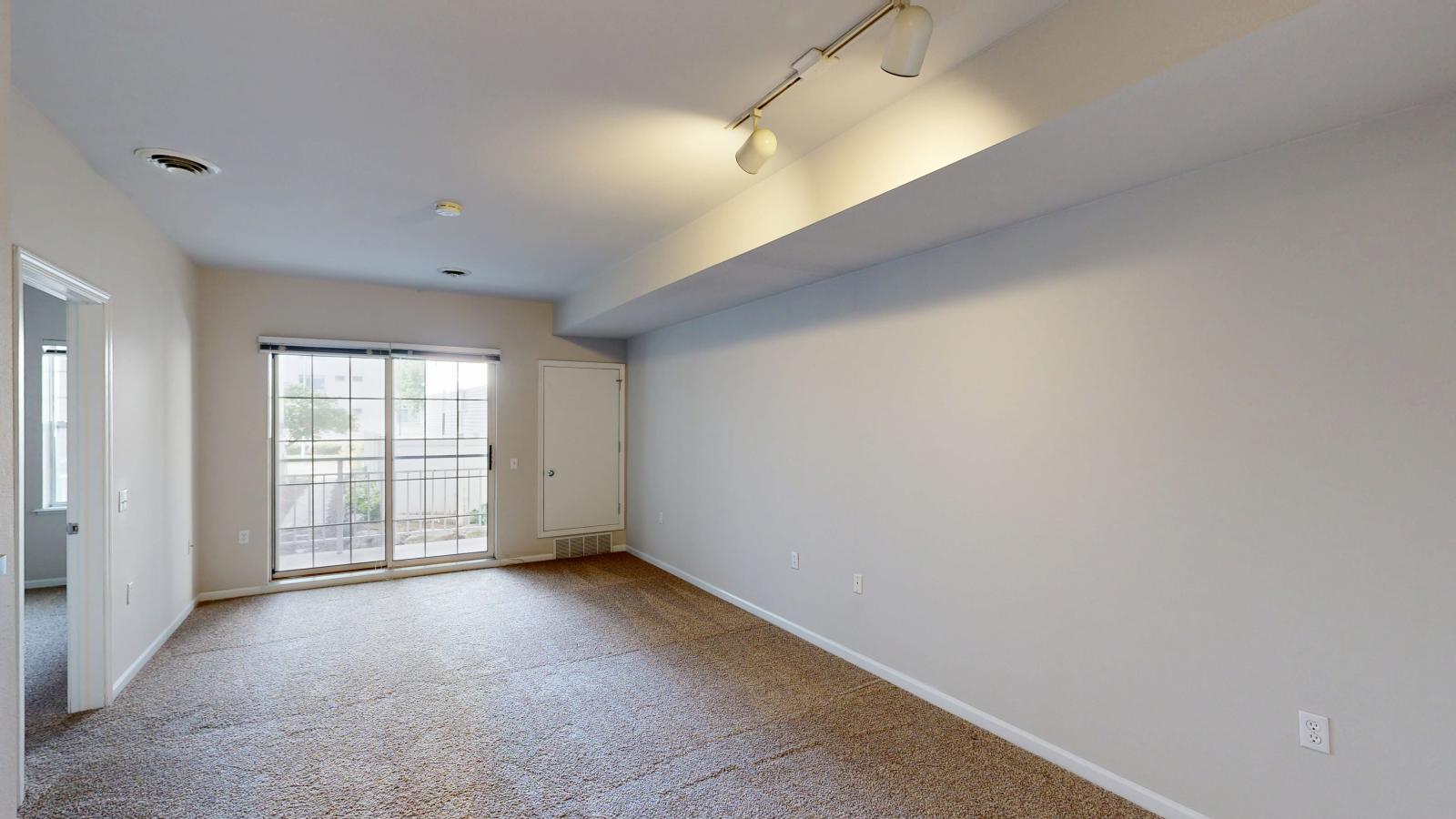 Cozy one-bedroom apartment living room with soft finishes and dining space at Wilson Bay Apartments.