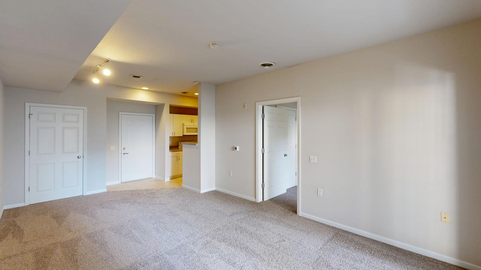 Cozy one-bedroom apartment living room with soft finishes and abundant natural light at Wilson Bay.