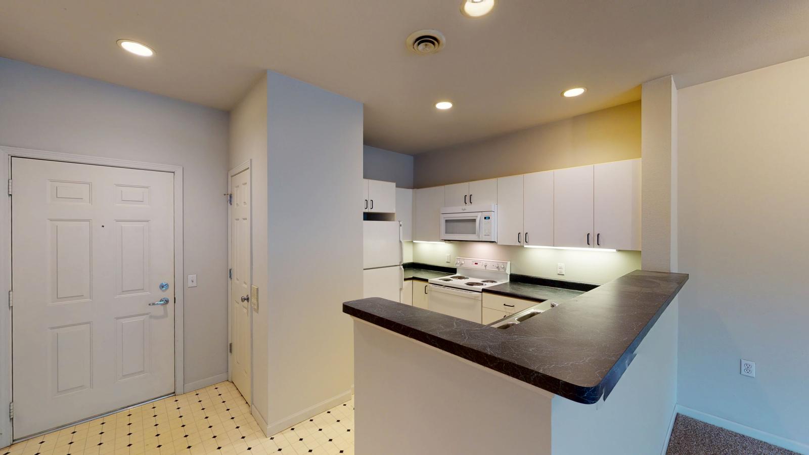 Classic-style kitchen with standard appliances and traditional cabinetry at Wilson Bay Apartment 208
