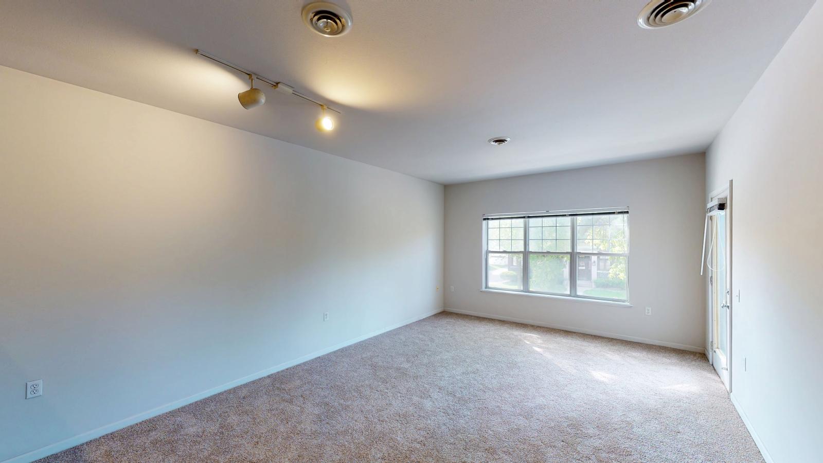 One-bedroom apartment with open floor plan and large windows at Wilson Bay Apartment 208