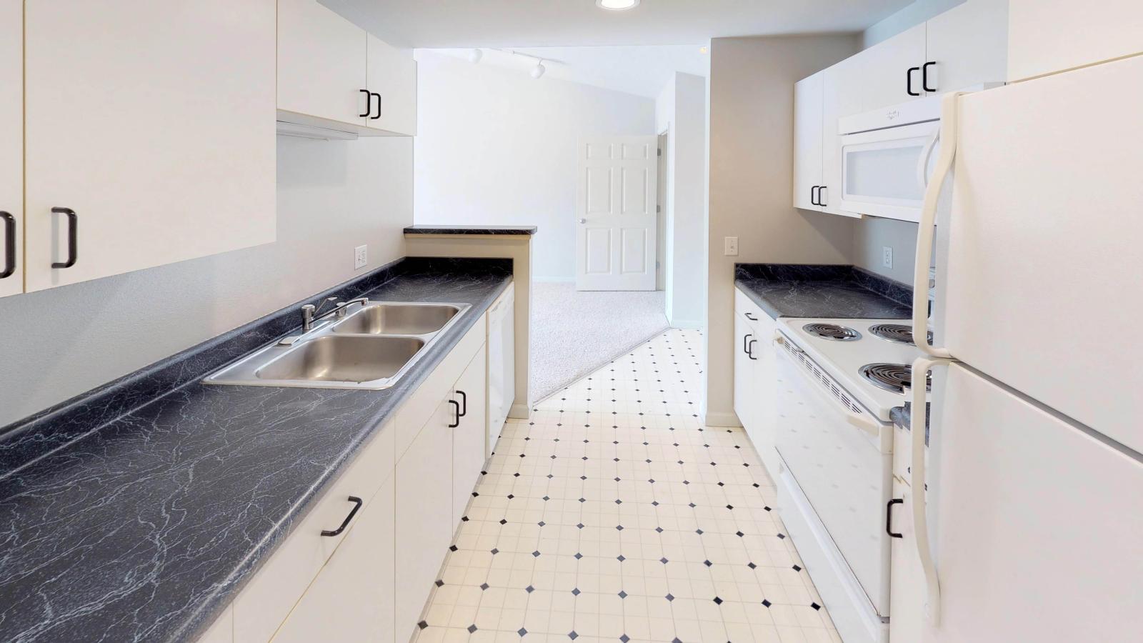 Kitchen with classic cabinetry and full-size appliances in a one-bedroom at Wilson Bay
