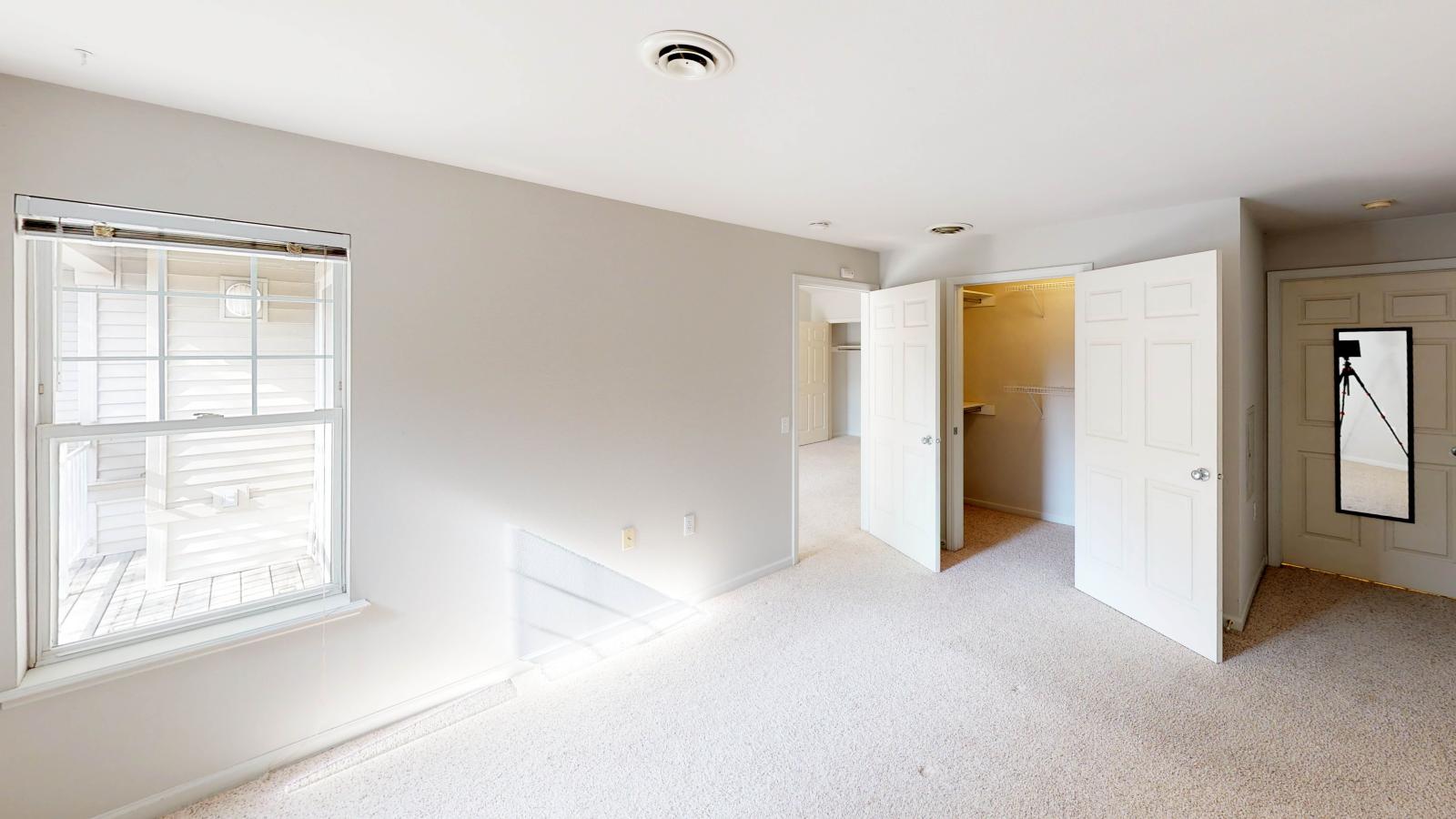 Spacious bedroom with a large closet and natural light at Wilson Bay Apartments