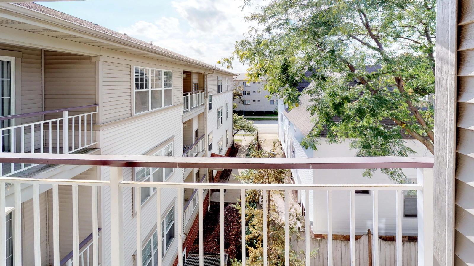Private balcony offering neighborhood views in a one-bedroom at Wilson Bay