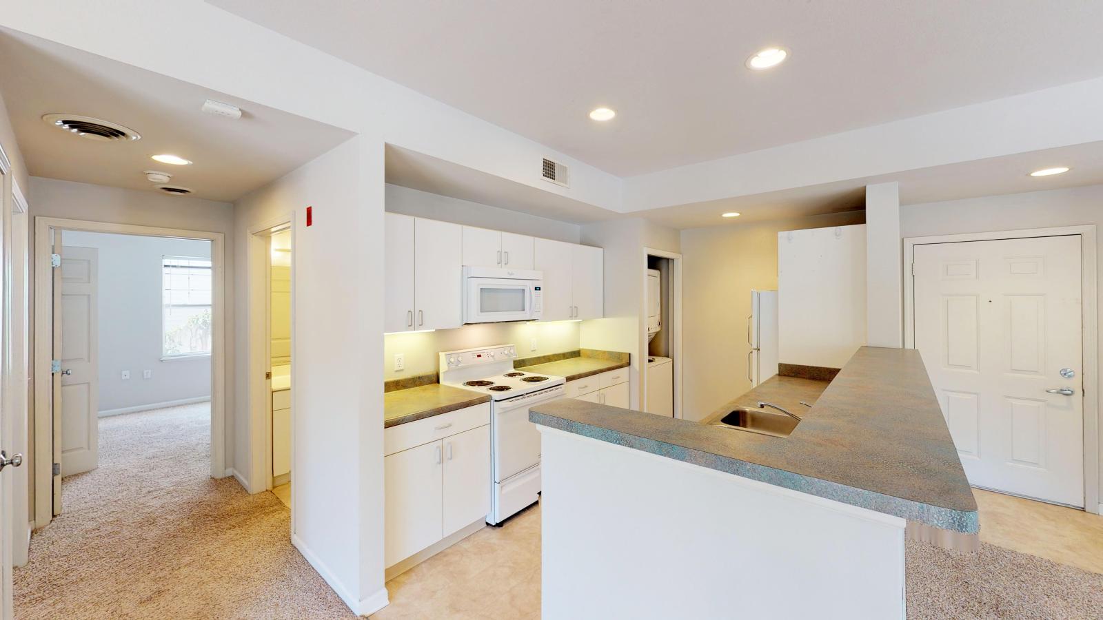 Functional kitchen with ample counter space and warm finishes in a two-bedroom at Wilson Bay