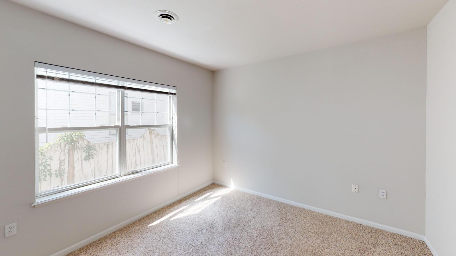 Cozy secondary bedroom with soft lighting and neutral finishes at Wilson Bay Apartments