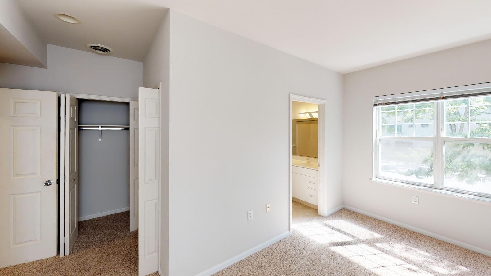 Large primary bedroom with a ample closet storage and bright windows at Wilson Bay