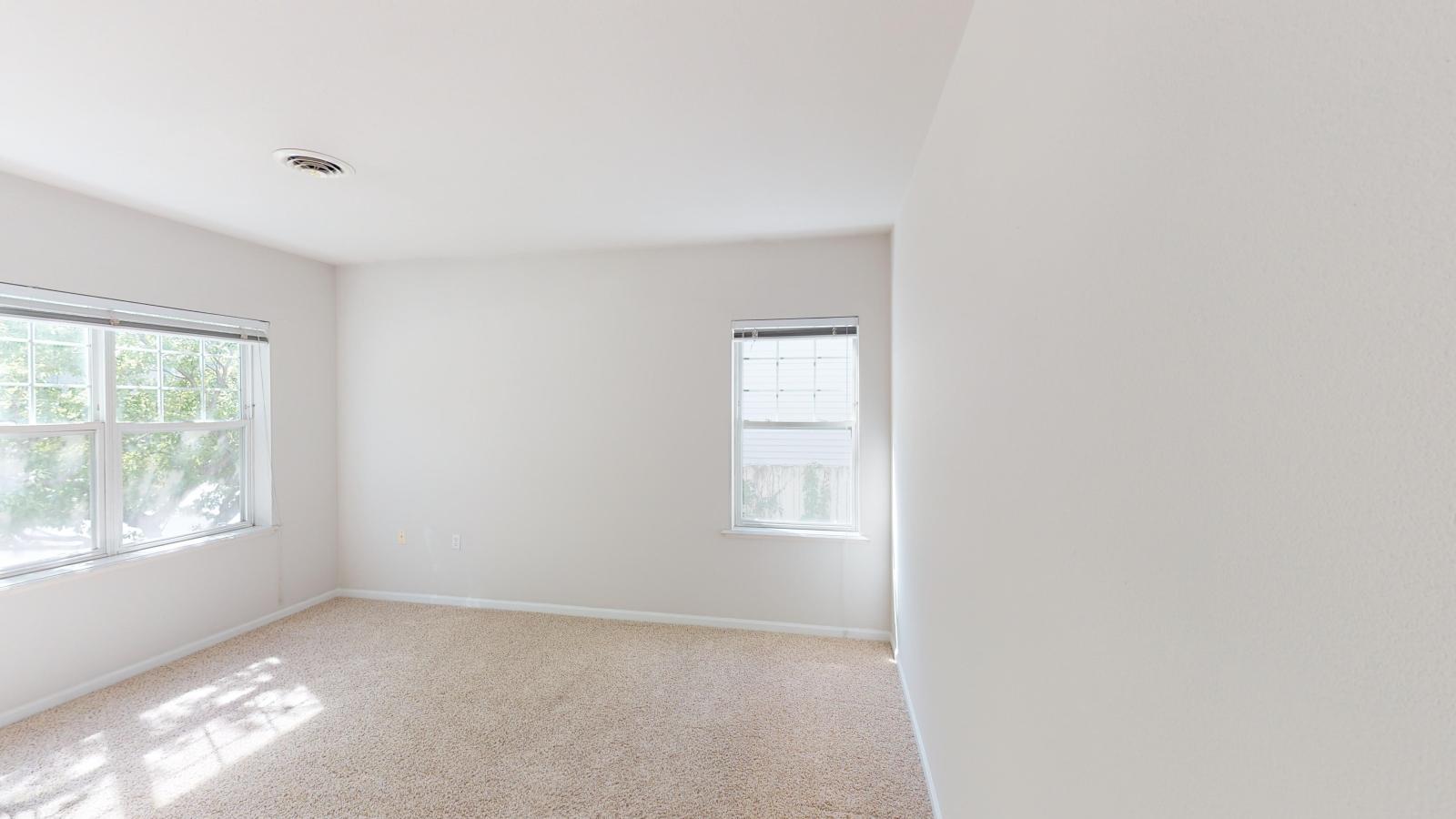Large primary bedroom with a walk-in closet and bright windows at Wilson Bay