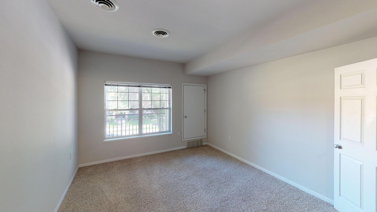 Spacious bedroom with a large closet and natural light at Wilson Bay Apartments