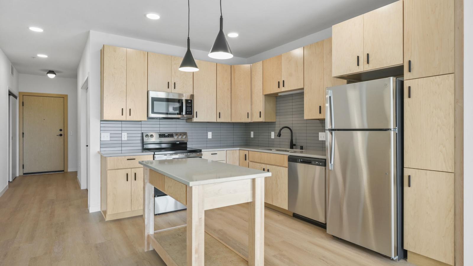 Stunning kitchen at The Irwin with cabinetry, countertops, and open layout to living space
