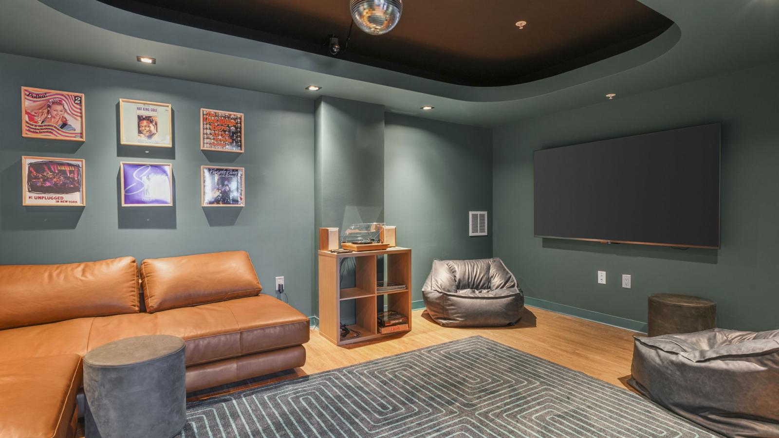 The Irwin lounge sitting area with cozy couch, TV, and turntable for residents to relax and unwind