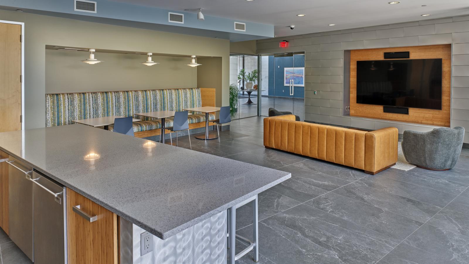 ULI Seven27 Apartments modern lounge with seating, TV area and large kitchen island